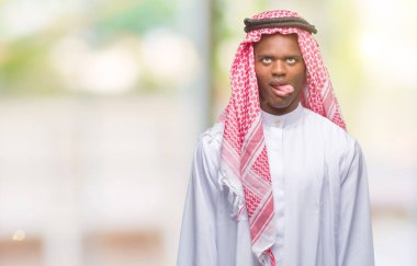 Geleneksel keffiyeh dilini izole arka plan üzerinde giyen genç Arapça Afrika adam out komik ifade ile mutlu. Duygu kavramı.