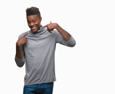 Afrikalı-Amerikalı genç kendinden emin gösterilen ve işaret parmakları diş ve ağız ile gülümseyen izole arka plan üzerinde. Sağlık kavramı.