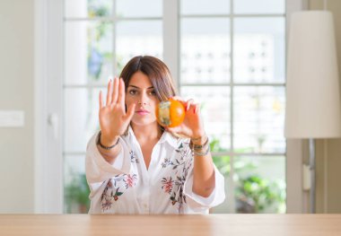 Genç kadın evde açık eliyle dur işareti ile ifade, ciddi ve kendinden emin yapıyor çürük turuncu holding savunma hareketi