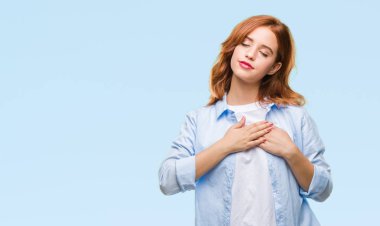 Eller izole arka plan ile gülümseyen üzerinde genç güzel iş kadın kapalı gözler ve yüzünde minnettar jest ile göğüs üzerinde. Sağlık kavramı.