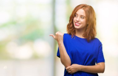 Seyir ve başparmak yanında yukarıyı mutlu yüz ile gülümseyen izole arka plan üzerinde genç güzel kadın.