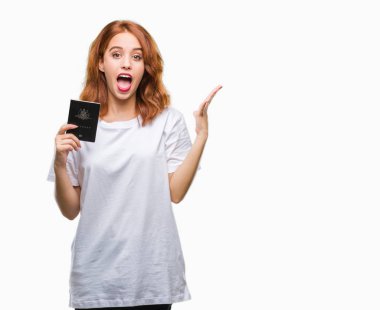 Avustralya pasaportu büyük gülümseme ile çığlık zaferini kutluyor ve ellerini kaldırdı izole arka plan çok mutlu ve heyecanlı, kazanan ifade üzerinde tutan genç güzel kadın