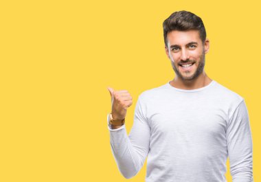 Yakışıklı delikanlı arıyor ve başparmak yanında yukarıyı mutlu yüz ile gülümseyen izole arka plan üzerinde.