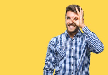 Genç yakışıklı adam gülümsüyor, parmakları ile mutlu yüz üzerinden seyir göz el ile ok jest yapıyor izole arka plan üzerinde.