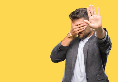 Genç yakışıklı iş adam elleriyle gözlerini kapsayan izole arka plan üzerinde ve stop jest ile acı ve korku ifadesi. Utandım ve negatif kavramı.