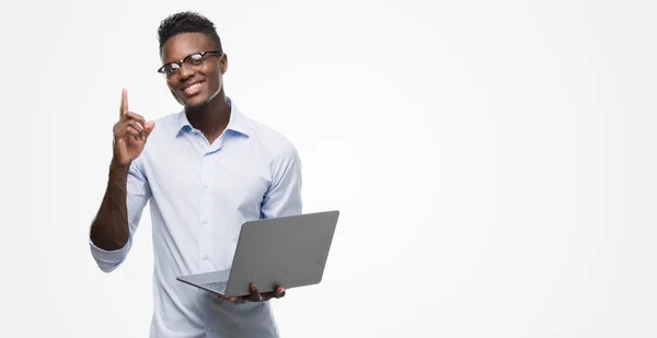年轻的非洲裔美国商人使用电脑笔记本电脑惊讶的想法或问题指着一个快乐的脸 — 图库照片