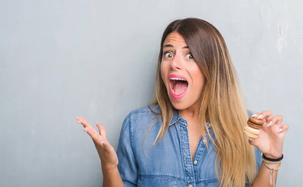 Jovem Mulher Adulta Sobre Parede Grunge Cinza Comendo Macarons Chocolate — Fotografia de Stock