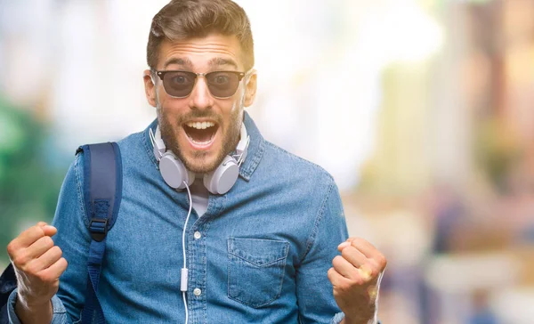 Joven Turista Guapo Con Auriculares Mochila Sobre Fondo Aislado Celebrando —  Fotos de Stock