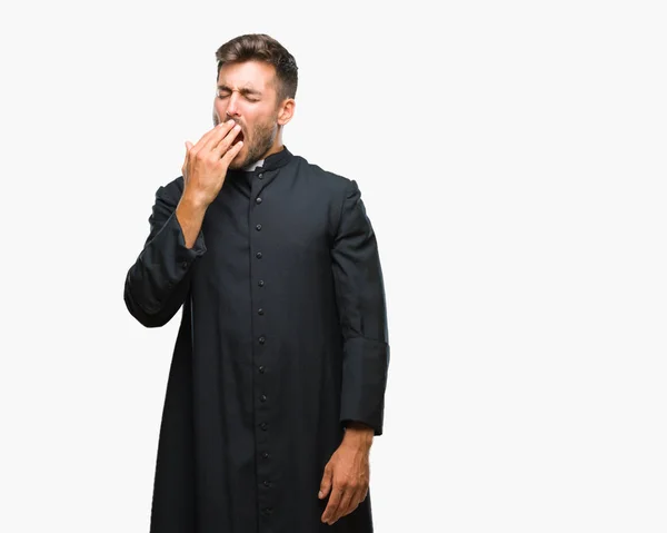 退屈あくび孤立の背景の上の若いカトリックのキリスト教司祭男は疲れて手で口を覆い 落ち着きと眠気 — ストック写真