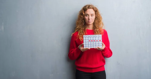 Joven Pelirroja Mujer Sobre Gris Grunge Pared Celebración Período Calendario — Foto de Stock