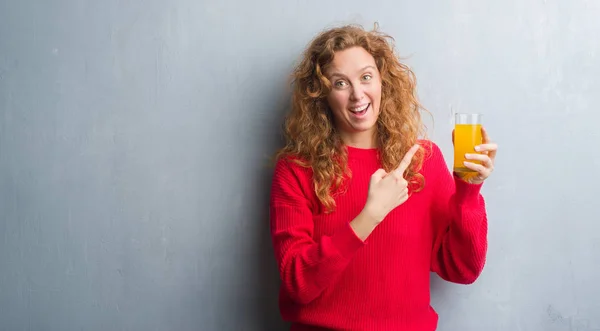 회색그런지 여자가 오렌지 주스를 마시고 있습니다 손가락으로 가리키는 합니다 — 스톡 사진