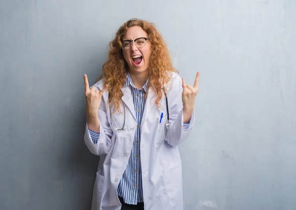 Joven Doctora Pelirroja Mujer Sobre Pared Gris Grunge Usando Abrigo —  Fotos de Stock