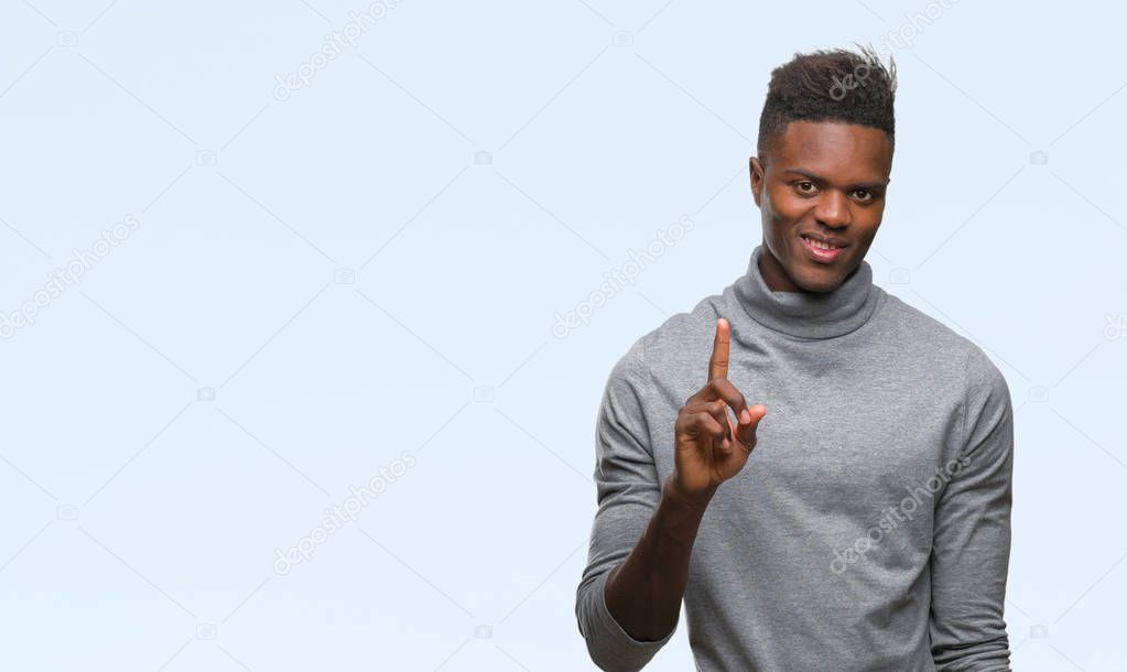 Young african american man over isolated background showing and pointing up with finger number one while smiling confident and happy.