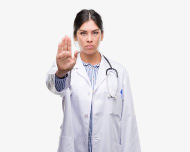 Genç İspanyol doktor kadın açık eliyle dur işareti ile ciddi ve kendine güvenen ifade, savunma hareketi yapıyor