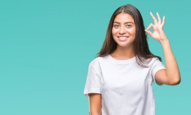 Gülümseyen izole arka plan üzerinde genç güzel Arap kadın el ve parmaklar ok işaretiyle yapıyor olumlu. Başarılı ifade.