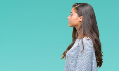 Genç güzel Arap kadın giyiyor kış kazak izole arka tarafına, seyir üzerinde dinlenmek doğal yüz emin gülümseme ile pozuyla profili.