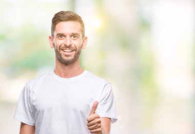 Yakışıklı delikanlı hareketi el ile mutlu yaşasın yapıyor izole arka plan üzerinde. Kameraya bakarak başarı gösteren ile ifade onaylama.