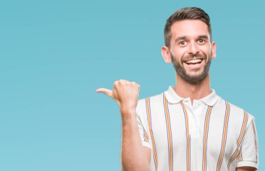 Yakışıklı delikanlı arıyor ve başparmak yanında yukarıyı mutlu yüz ile gülümseyen izole arka plan üzerinde.