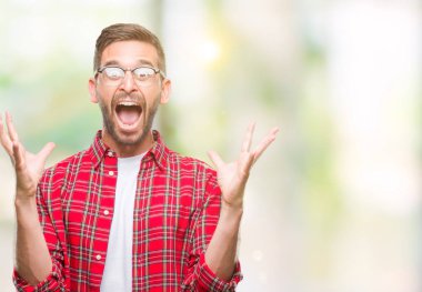 Yakışıklı delikanlı deli kutluyor ve silah ile başarı için heyecanlı çığlık kaldırdı ve açık gözleri hayret izole arka plan üzerinde. Kazanan kavramı