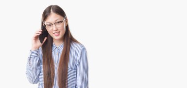 Arka plan ayakta ve diş gösterilen kendine güvenen bir gülümsemeyle gülümseyerek mutlu bir yüz ile konuşan Genç Çinli kadın izole