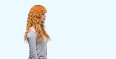 Tarafına, arayan genç Kızıl saçlı kadın dinlenmek doğal yüz emin gülümseme ile pozuyla profili.