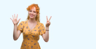 Gösterilen ve parmakları ile işaret genç Kızıl saçlı kadın kendinden emin ve mutlu gülümseyerek süre yedi numara.