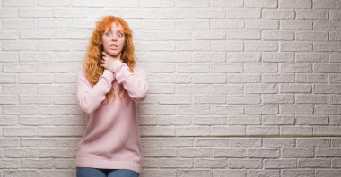 Tuğla üzerinde duran genç Kızıl saçlı kadın duvar bağırarak ve çünkü boğmak acı kendi ellerimle öldürürüm. Sağlık sorunu. Yaralarından ve intihar kavramı.