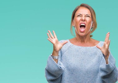 Üzerinde kış kazak giyen orta yaş üst düzey İspanyol kadın arka plan deli izole ve deli bağırarak ve agresif ifade ve silah kaldırdı bağırıyor. Hayal kırıklığı kavramı.