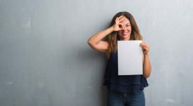 Banka kağıt levha ile ok işareti ile el parmaklarının arasından seyir göze yapıyor gülümseyen mutlu yüz tutan orta yaş İspanyol kadın