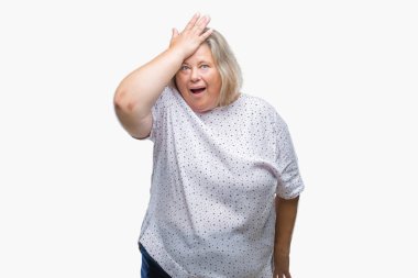 Senior plus size caucasian woman over isolated background surprised with hand on head for mistake, remember error. Forgot, bad memory concept. clipart