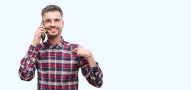 Kendisi için sürpriz yüz işaret parmağı ile telefonda konuşan genç yenilikçi yetişkin adam