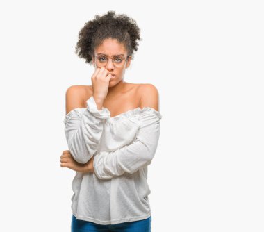 Stresli ve gergin elle çivi ısırma ağzına bakarak izole arka plan üzerinde gözlük takan genç afro Amerikalı kadın. Anksiyete sorunu.