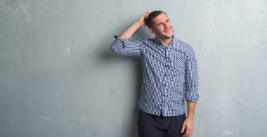 Gri grunge duvarın üzerinden beyaz delikanlı yanıltır ve soru hakkında merak ediyorum. Şüphe, kafasına el ile düşünme ile belirsiz. Dalgın kavramı.