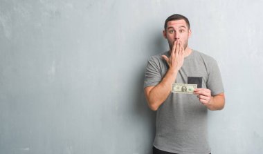 Hata, korku, sessizlik içinde gizli kavramı korkmuş ifade için utanç ile beyaz delikanlı bir dolar kapağı ağız el ile gösterilen gri grunge duvarın üzerinden şok