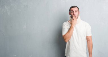 Hata, korku, sessizlik içinde gizli kavramı korkmuş ifade için utanç ile boyun tasması kapak ağız el ile giyen gri grunge duvarın üzerinden yaralı genç beyaz adam şok