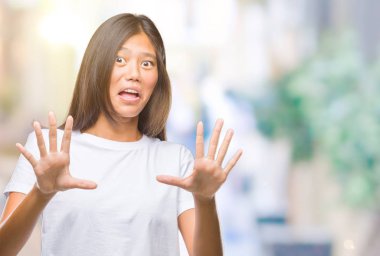 Genç Asyalı kadın şok bağırarak korkuyor ve dehşet korku ifade dur hareketi el ile ile izole arka plan üzerinde. Panik kavramı.