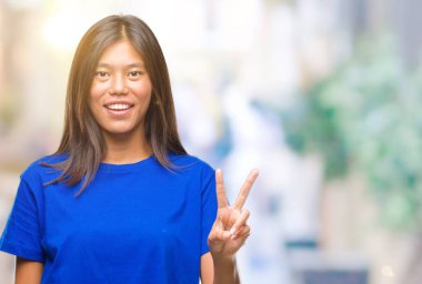 Genç Asyalı kadın gösterilen ve parmakları ile işaret izole arka plan üzerinde ikincisi ise kendinden emin ve mutlu gülümseyerek.