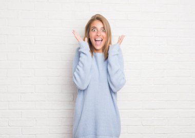Beyaz tuğla güzel genç kadın çılgın ve başarı için hayran kaldırdı kollarını açarak kutlama duvar ve heyecanlı çığlık gözleri açık. Kazanan kavramı