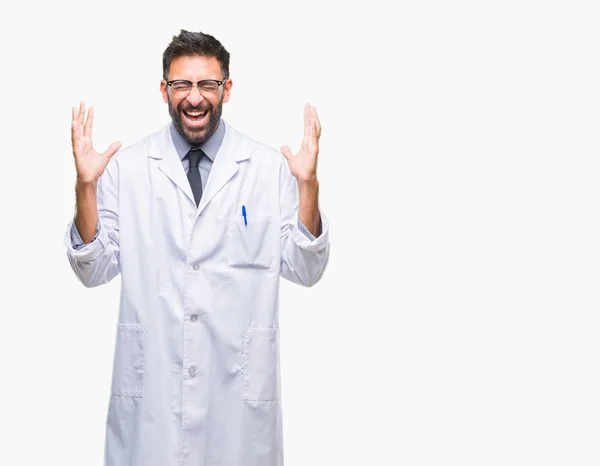 成年西班牙裔科学家或医生穿白色大衣在孤立的背景下庆祝疯狂和疯狂的成功与手臂举起 闭上眼睛尖叫兴奋 赢家理念 — 图库照片