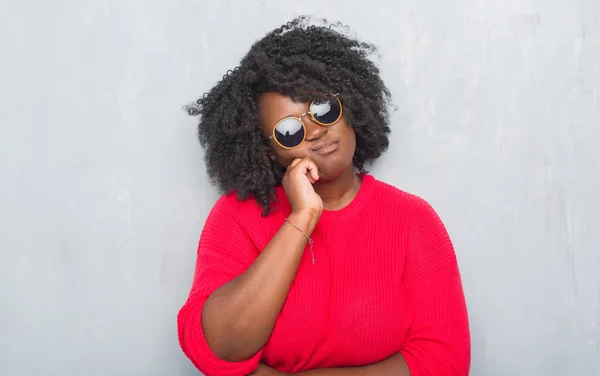 若いアフリカ系アメリカ人プラス探して疲れや交差腕を持つうつ病問題と退屈を考えてレトロ サングラス グレー グランジ壁上の女性 — ストック写真