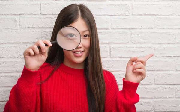 Jonge Chinese Vrouw Bakstenen Muur Kijken Vergrootglas Erg Blij Met — Stockfoto