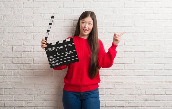 Junge Chinesin Über Weiße Backsteinmauer Hält Klappbrett Sehr Glücklich Und — Stockfoto