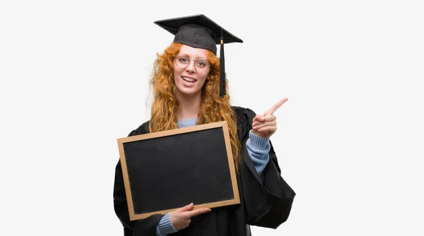 Joven Estudiante Pelirroja Vistiendo Uniforme Graduado Sosteniendo Pizarra Muy Feliz — Foto de Stock