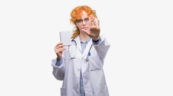 赤毛の若い医師女性持株防衛ジェスチャー 深刻な自信を持って式に一時停止の標識をやって開いた手と無罫 — ストック写真