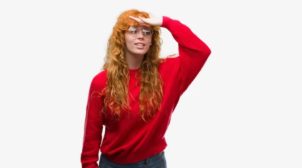 身穿红毛衣的年轻红发女子非常高兴 微笑着望着远方的手头 搜索概念 — 图库照片