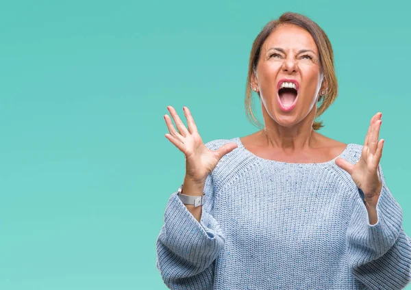 Üzerinde kış kazak giyen orta yaş üst düzey İspanyol kadın arka plan deli izole ve deli bağırarak ve agresif ifade ve silah kaldırdı bağırıyor. Hayal kırıklığı kavramı.