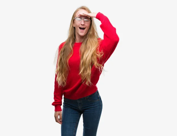金髪の 代女性非常に幸せと笑顔の頭上の手で遠く離れている赤いセーターを着ています 概念を検索 — ストック写真