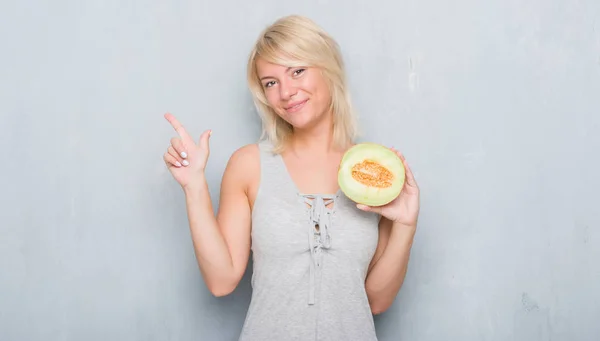 Vuxen Kaukasisk Kvinna Över Grunge Grå Vägg Äta Cantaloupemelon Mycket — Stockfoto