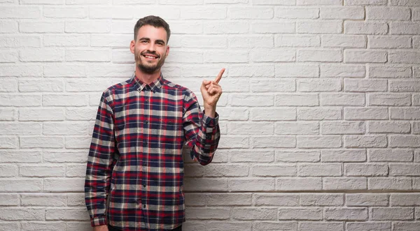 Homem Adulto Jovem Sobre Parede Tijolo Branco Muito Feliz Apontando — Fotografia de Stock