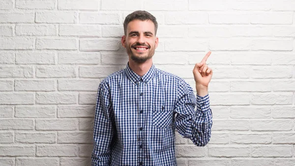 Homem Adulto Jovem Sobre Parede Tijolo Branco Muito Feliz Apontando — Fotografia de Stock
